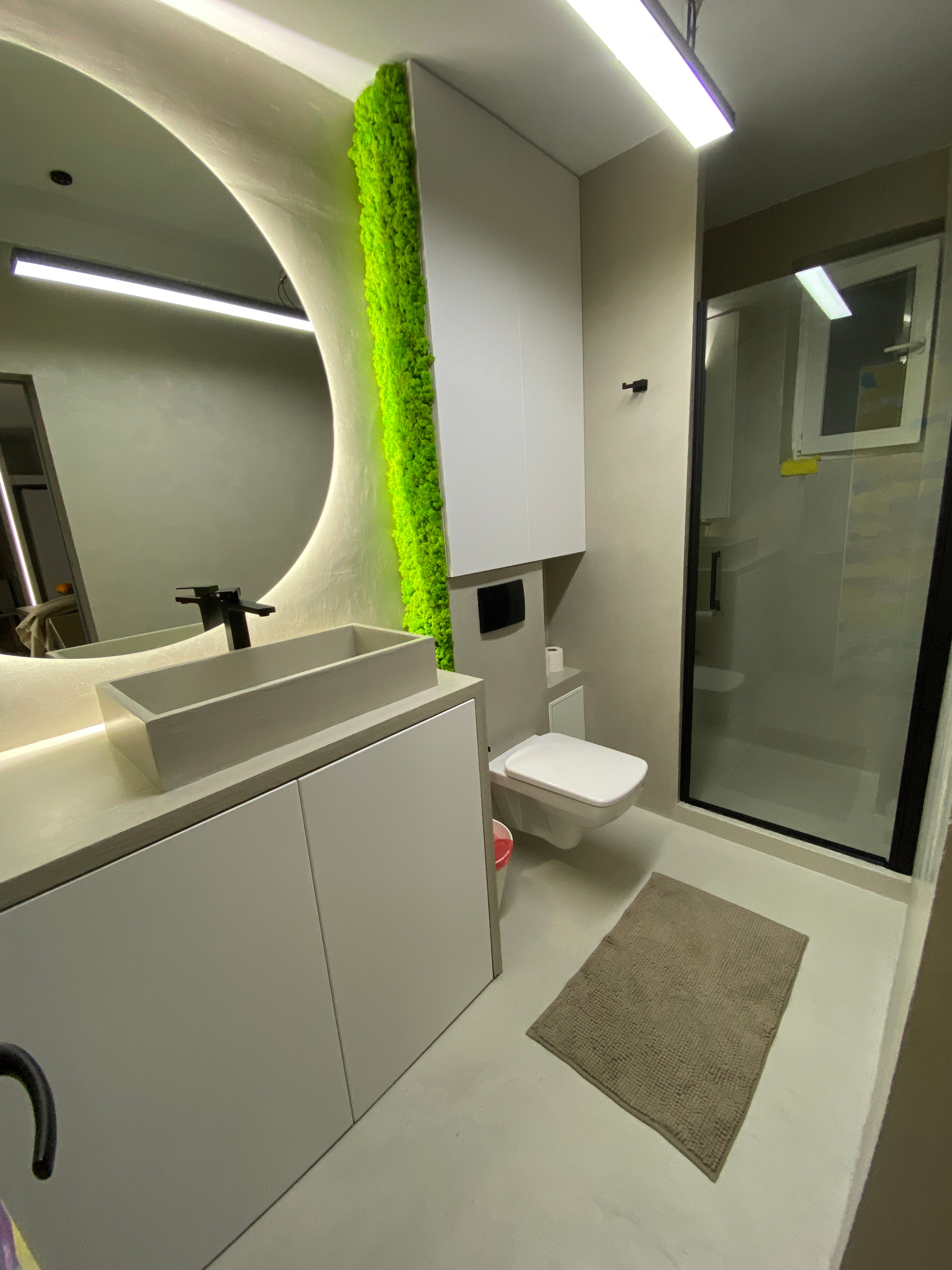 Panou decorativ vertical cu licheni stabilizați verde primăvară, montat într-o baie modernă cu design minimalist și iluminare subtilă.
