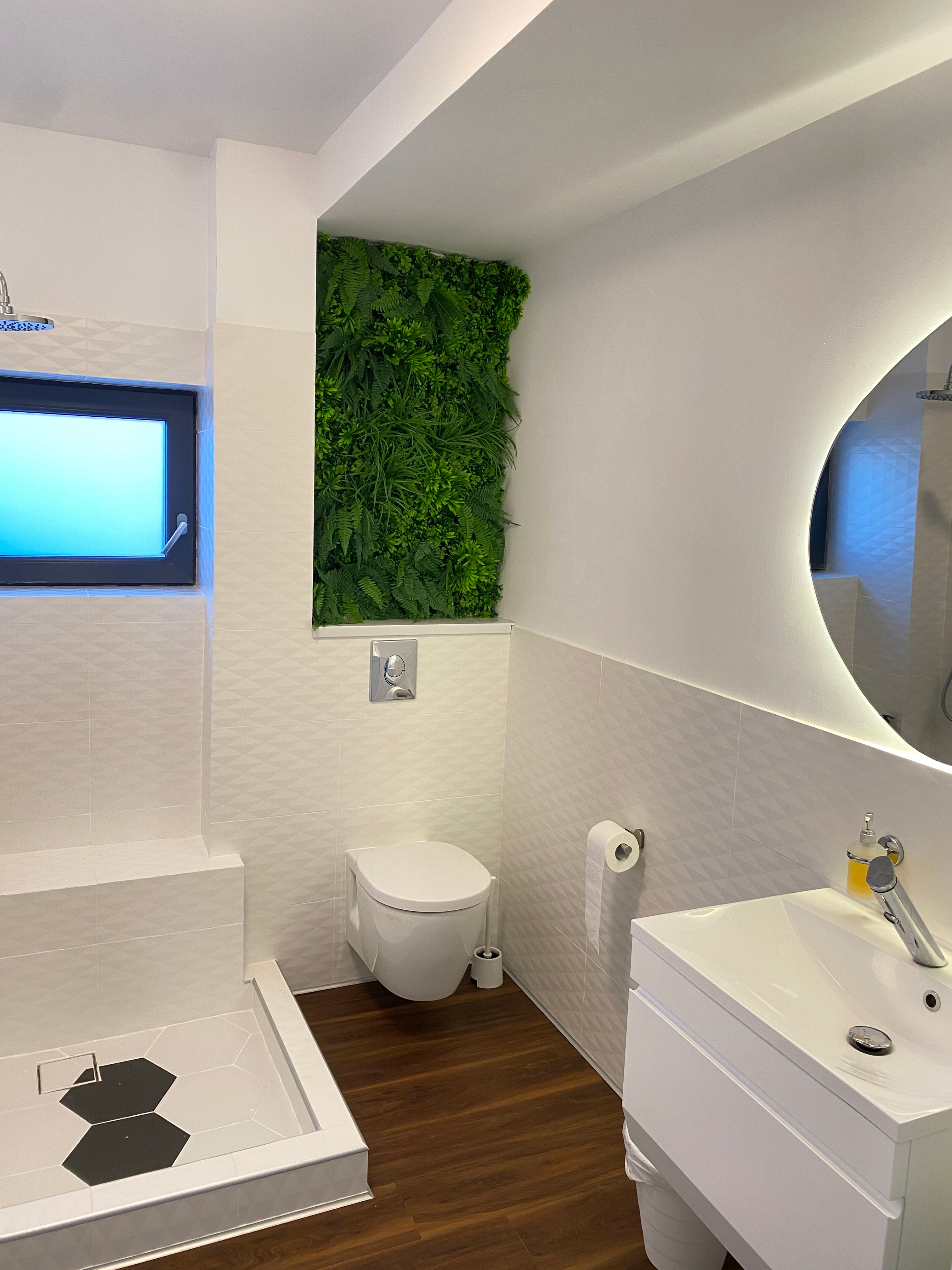 Baie modernă cu perete decorativ din plante artificiale, pentru un aspect natural și elegant