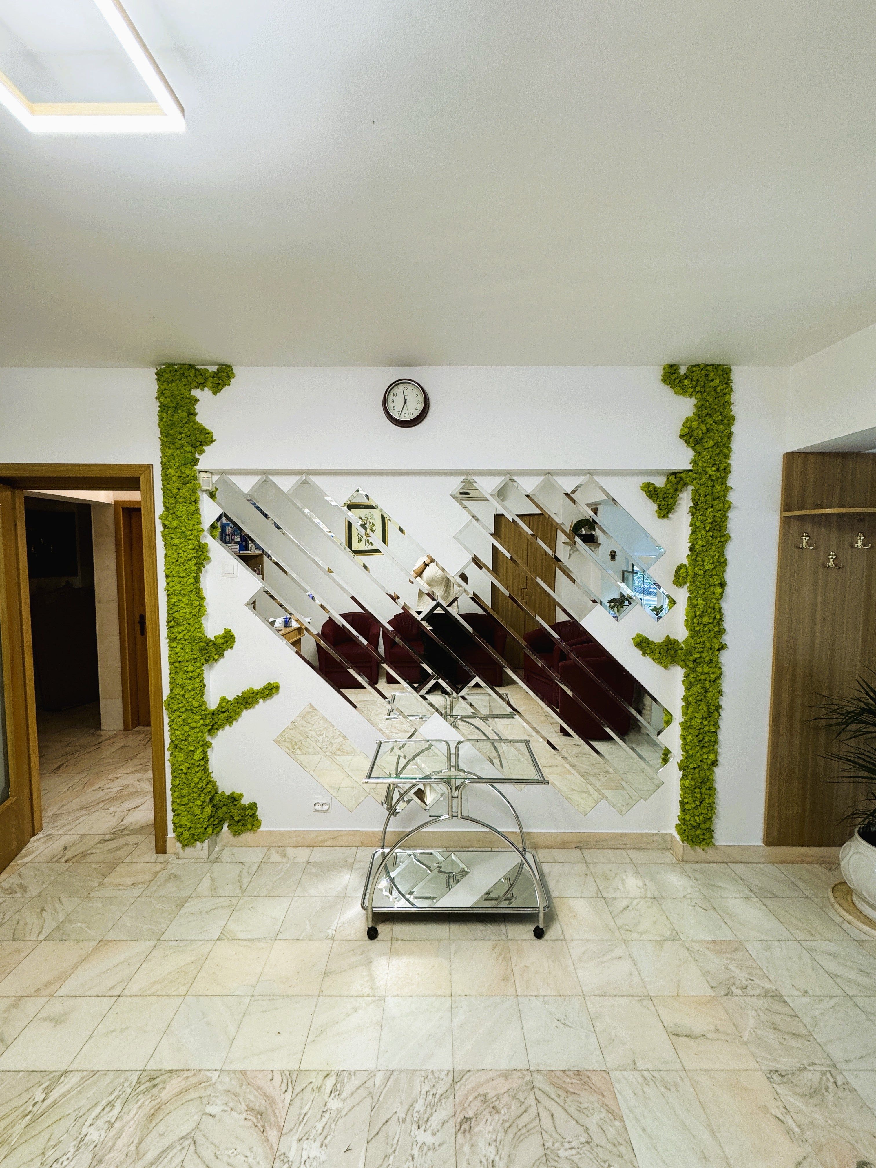 Decor cu licheni stabilizați aplicat pe conturul unei oglinzi decorative într-un hol modern
