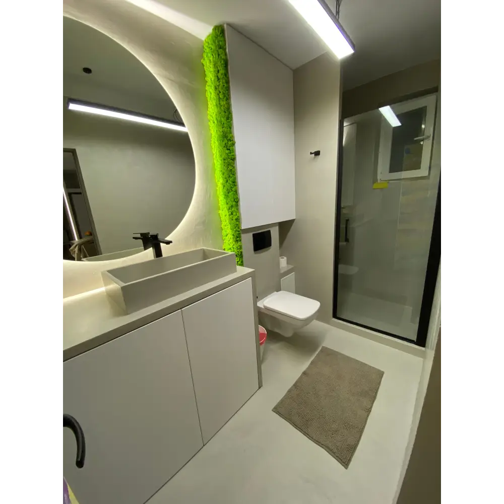 Panou decorativ vertical cu licheni stabilizați verde primăvară, montat într-o baie modernă cu design minimalist și iluminare subtilă.
