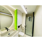 Panou decorativ vertical cu licheni stabilizați verde primăvară, montat într-o baie modernă cu design minimalist și iluminare subtilă.
