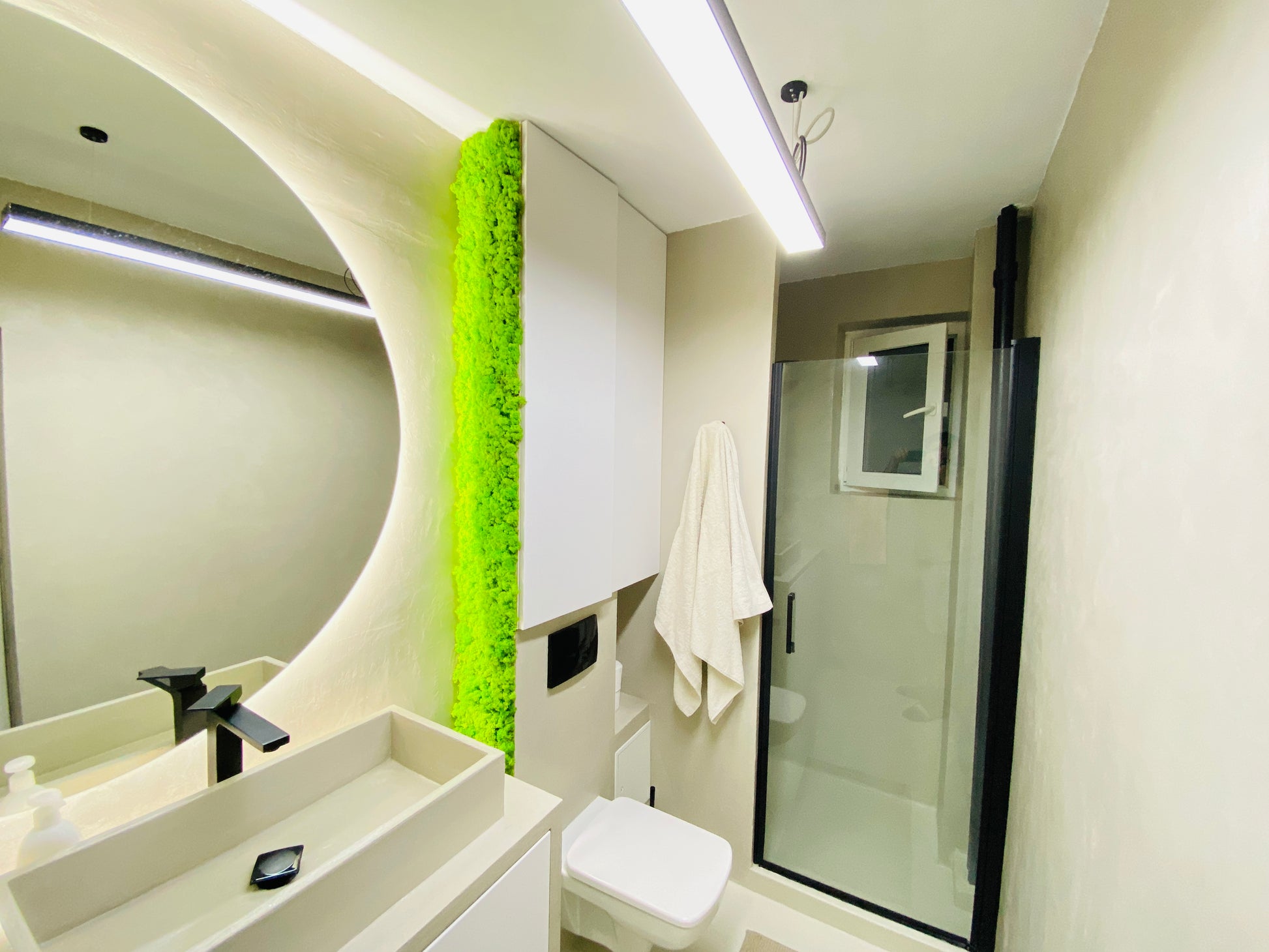 Panou decorativ vertical cu licheni stabilizați verde primăvară, montat într-o baie modernă cu design minimalist și iluminare subtilă.

