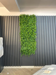 Perete decorativ  modern cu riflaje verticale și plante artificiale verzi