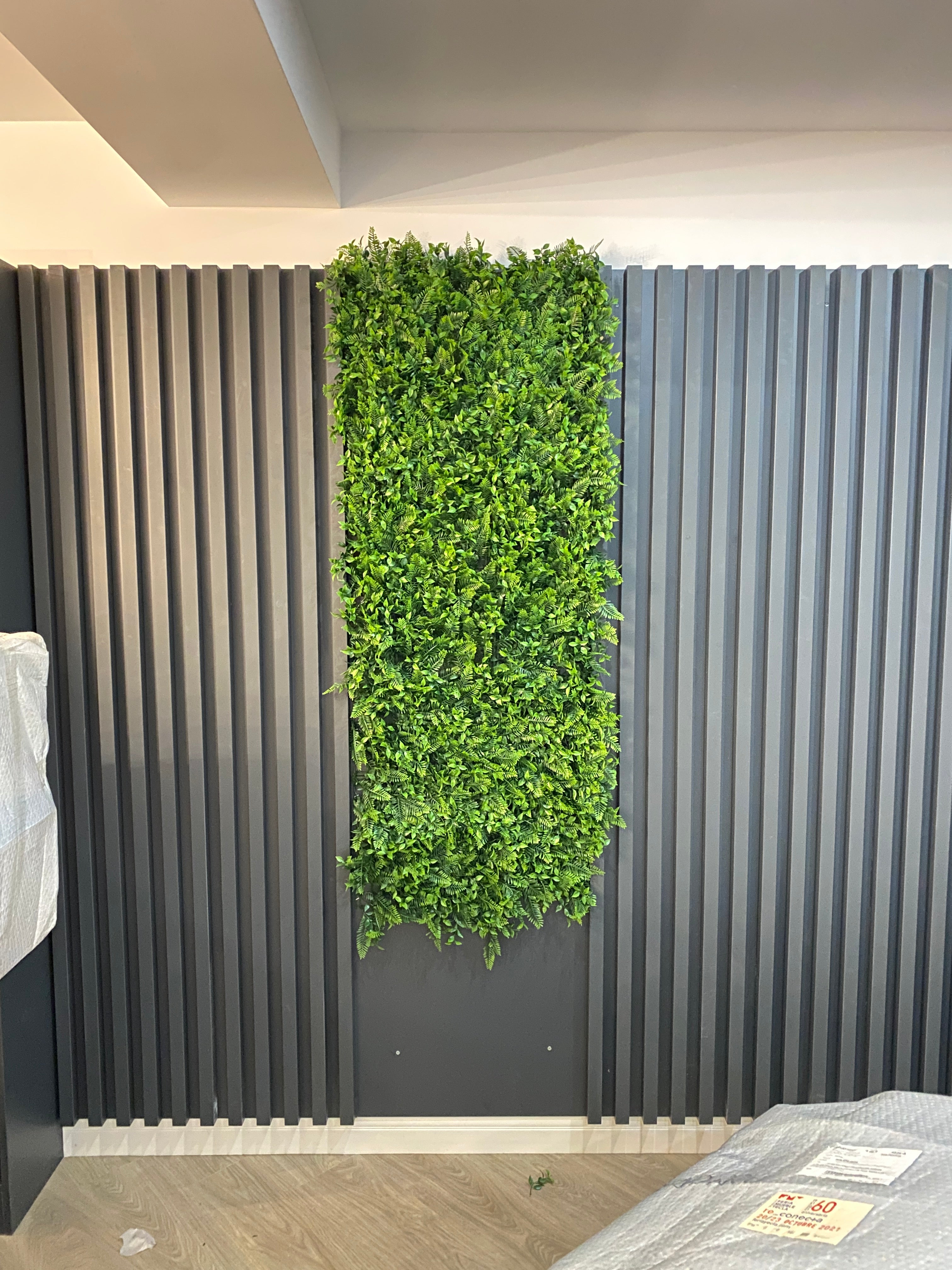 Perete decorativ  modern cu riflaje verticale și plante artificiale verzi
